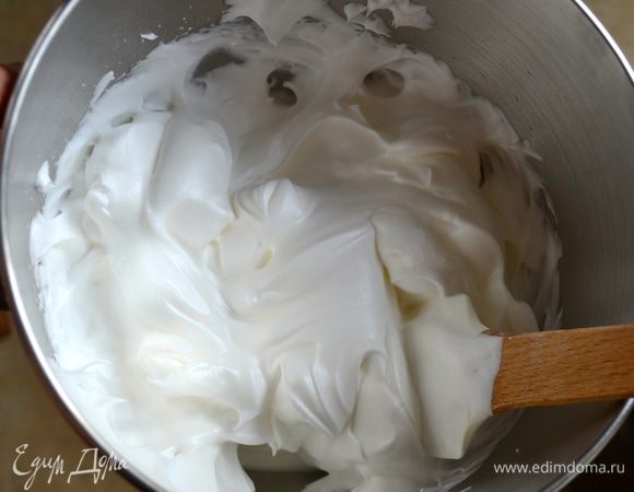 Начать взбивать яичные белки. Как только появится пена, всыпать, постепенно добавляя ложками, сахар и разрыхлитель. У взбитых в крепкую пену белков будет гладкая блестящая поверхность.