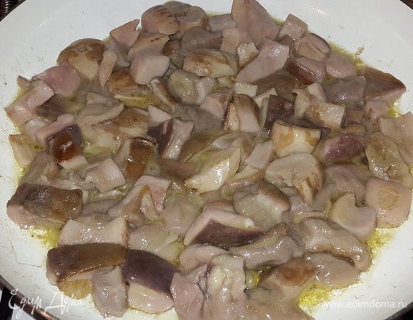 В сковороде разогреваем оливковое масло вместе с кусочком сливочного. Выкладываем предварительно отваренные грибы. Обжариваем на среднем огне до выпаривания жидкости. Параллельно режем лук на четверть кольца.