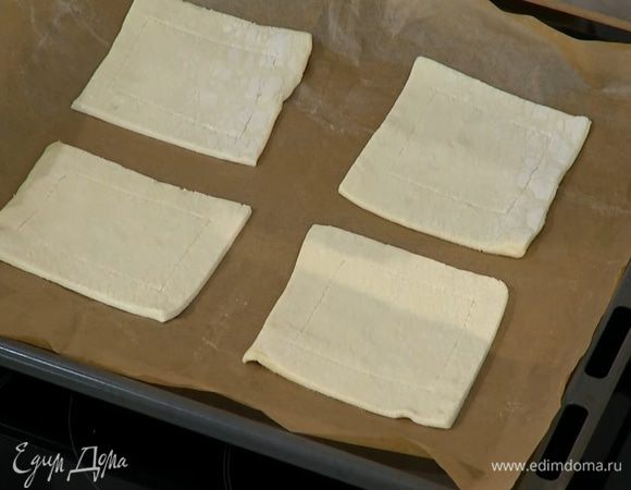 Противень выстелить бумагой для выпечки и выложить квадратики теста.