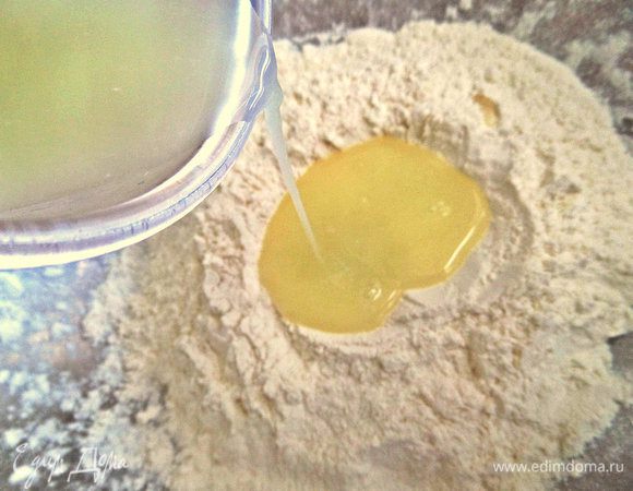 Вливаем в просеянную муку сыворотку комнатной температуры или чуть тёплую. 