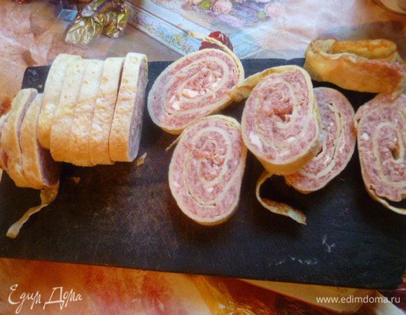 Затем один рулет вынуть, дать слегка подтаять, чтобы было легче было резать.
Нарезать на кусочки 1-1,5 см толщиной.