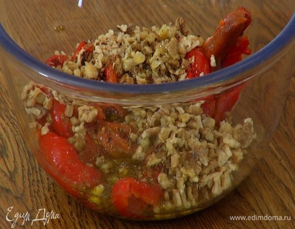 Добавить грецкие орехи, измельченный чеснок, полить все заправкой и перемешать.