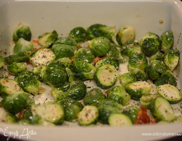 В жаропрочное блюдо выложить порезанную и очищенную брюссельскую капусту. Смешать с приготовленной смесью. Добавить 2 крупно порезанных зубчика чеснока. Перемешать. Поставить в разогретую духовку на 20-25 мин.
