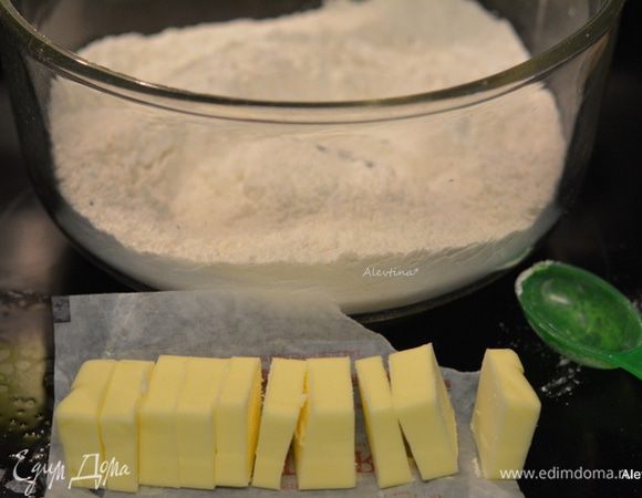В большой емкости смешать муку, разрыхлитель, соль. Масло холодное нарезать на кусочки.