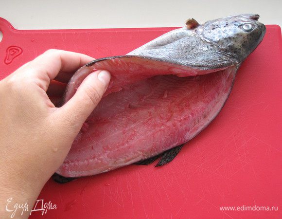 Острым ножом аккуратно сделать два разреза вдоль хребта. Удалить позвоночник вместе с реберными костями. Выпотрошить рыбку через получившийся разрез. Удалить оставшиеся косточки. Рыбку промыть. просушить бумажными полотенцами. 