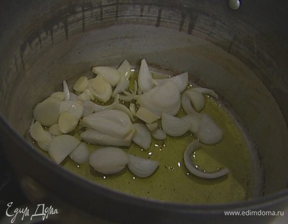 В тяжелой кастрюле разогреть 3 ст. ложки оливкового масла и обжарить лук и чеснок до прозрачности.