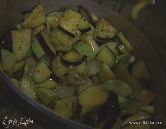 Выложить в кастрюлю с луком нарезанные баклажаны и кабачки, влить оставшееся масло, все перемешать.