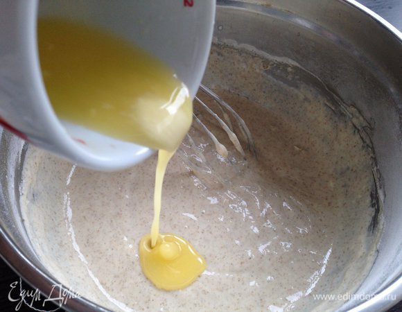 К получившейся кефирно-яичной массе добавить сухие ингредиенты, перемешать до однородности. Влить растопленное сливочное масло. 