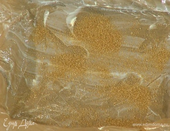 Форму для выпечки выстелить бумагой для выпечки, смазать ее оставшимся сливочным маслом и посыпать сахаром.