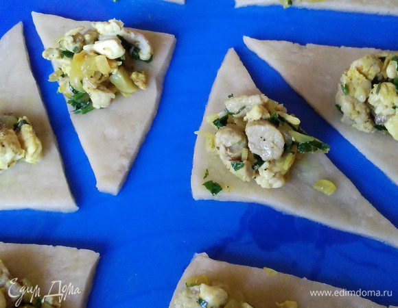 Тесто разделить на 2 части, раскатать тонко, 2-3 мм толщиной. Для мясных самосов я нарезала тесто на треугольнички, добавила по чайной ложке начинки.