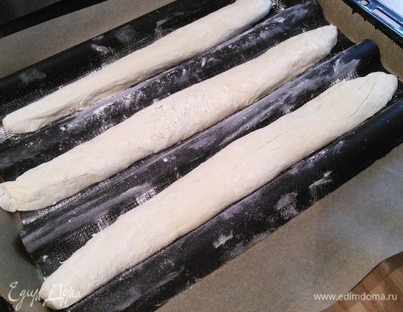 У меня тесто пролежало в холодильнике около 72. В утро выпечки очень аккуратно разрежьте тесто на три части. Рабочую поверхность припылите мукой, много муки не потребуется, т. к. тесто уплотнилось. Сформируйте багеты и выложите на противень. Хорошо выпекается багеты если сделать из фольги импровизированную форму (у меня специальная силиконовая). Оставьте заготовки под плёнкой на 15 мин для адаптации при комнатной температуре на отдых. 