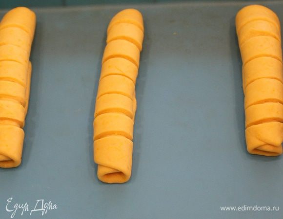 Скрутить в трубочки, выложить на противень на расстоянии друг от друга.