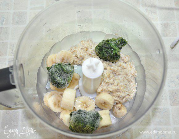 Для зелёного слоя: ополоснуть блендер, сложить в него распаренные овсяные хлопья, порезанные бананы и замороженные листья шпината. Всё взбить на высокой скорости до однородности. 