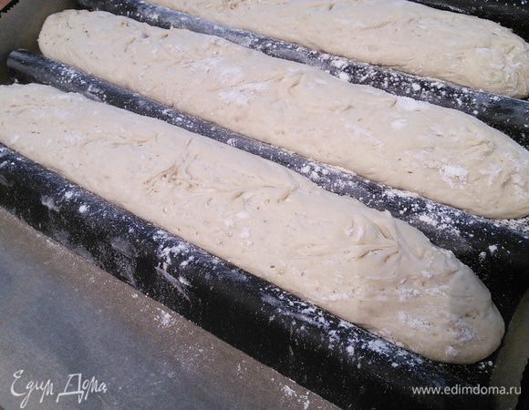 Багеты присыпьте мукой и под плёнкой поставьте на пол часа в тёплое место (у меня духовка разогретая до 25°, это рекомендация автора рецепта). Не жалеем муки, иначе плёнка приклеется к тесту. Достаньте багеты, разогрейте духовку до 250°. Тем временем сделайте надрезы, выпекайте 25 мин с паром, уменьшая температуру до 230 °. 