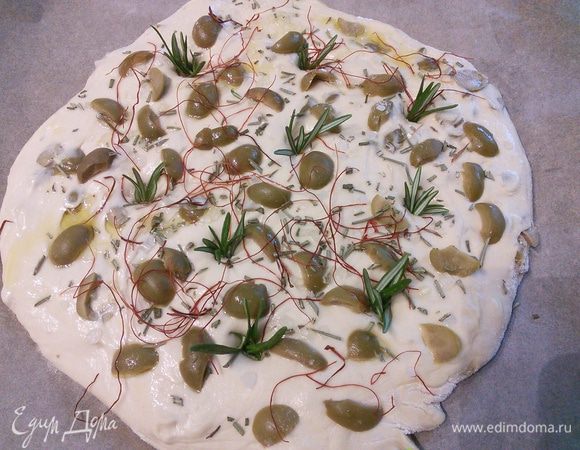 Сформировала фокаччу, оставшиеся оливки, крупную соль, розмарин разложила по лепёшке, пальчиком сделала вмятины и поместила внутрь кустики свежего розмарина и сбрызнула оливковым маслом. 