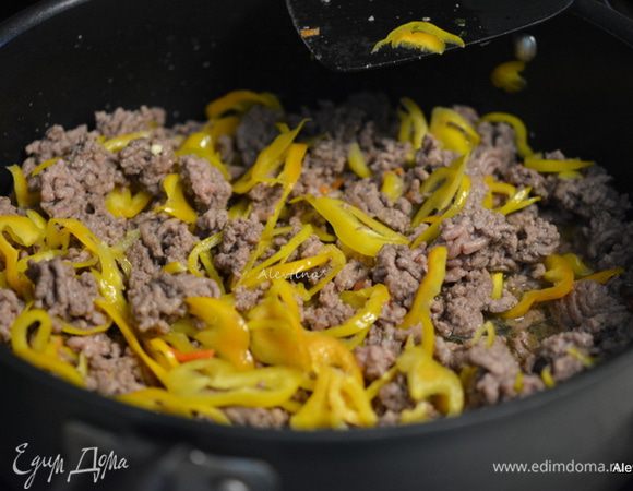 Разогреть духовку до 190C. 
Обжарить слегка говяжий фарш нежирный на разогретой сковороде. Добавить нарезанный цветной перец. Обжаривать еще 5 мин. Слить жир.