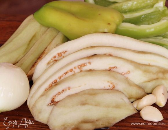 Баклажаны очищаем, нарезаем пластинами толщиной 0.5 см. Перец, лук и чеснок чистим.