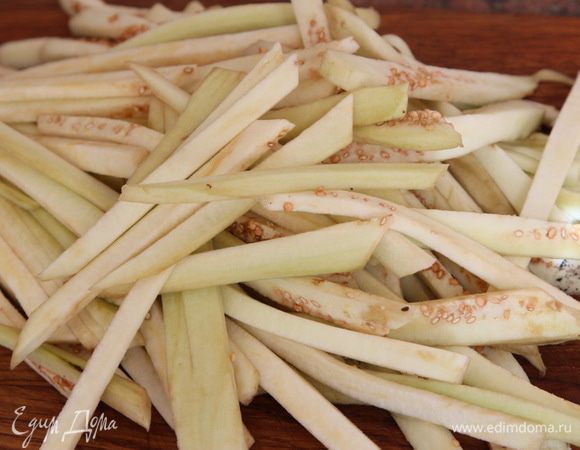 Далее нарезаем баклажаны соломкой, выкладываем в глубокую емкость.