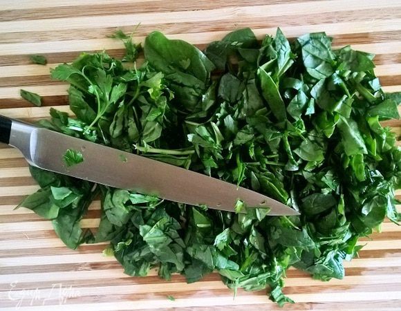 Помыть и обсушить петрушку (среднего размера пучок) и шпинат. Нарубить зелень не слишком мелко. 