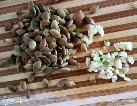 Обжарить тыквенные семечки и порубить мелко дольку чеснока. Перемешать наши ингредиенты вместе: зелень, морковь, семечки и чеснок. 