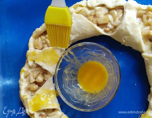 Смешать второй желток с щепоткой сахарной пудры и смазать пирог.