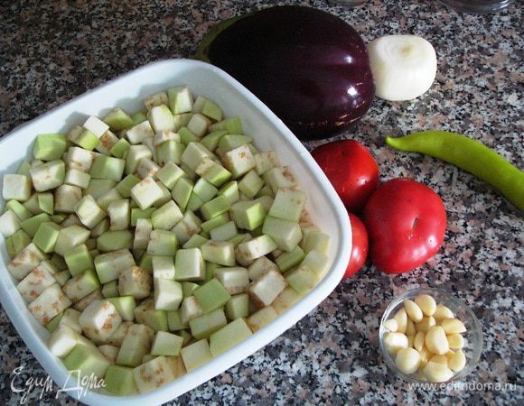 Я использовала один круглый крупный баклажан. Его надо очистить, нарезать кубиками и погрузить в соленую воду на 15 минут. Чеснок почистить.