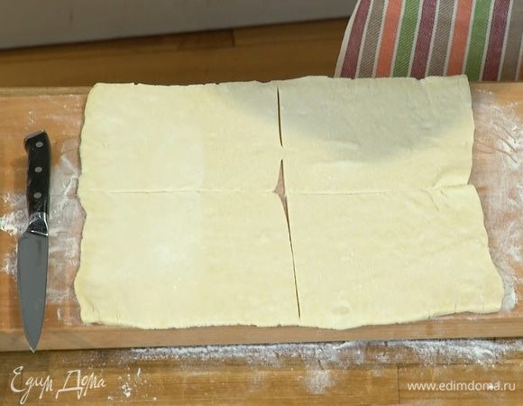 Рабочую поверхность посыпать мукой, раскатать тесто и разрезать на 4 квадрата.
