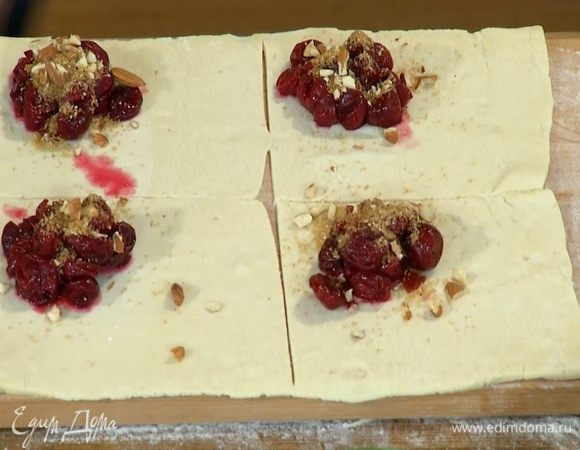 На один угол теста, отступая от края по 1 см, выложить вишню и посыпать орехами с сахаром и корицей.