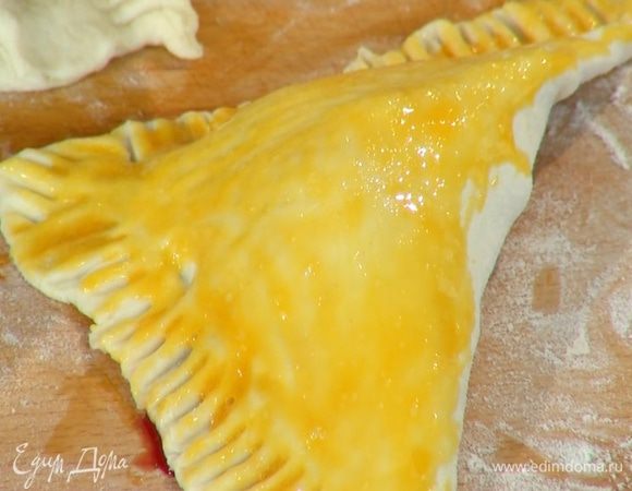 Желток посолить, перемешать и с помощью кисточки смазать слойки.