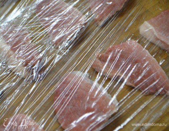 Мясо помыть, обсушить и нарезать на порционные куски. Выложить на разделочную доску, накрыть пищевой пленкой и хорошо отбить.