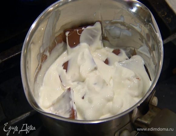 Приготовить крем: в небольшой кастрюле соединить шоколад со сметаной и растопить все на медленном огне, периодически помешивая.