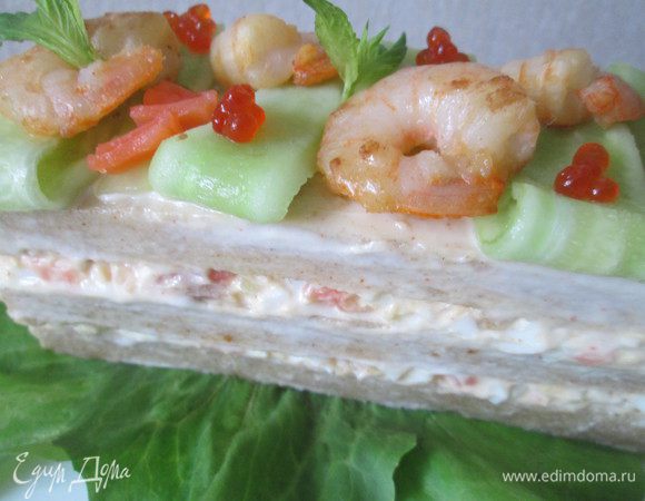 Теперь украшаем верх нашего айсберга: сначала кладем полоски огурцов, между ними королевские креветки, которые я обжарила в масле с измельченным чесноком (чесночный порошок не использовала).
Верхушку можно дополнительно украсить икрой лососевых.
