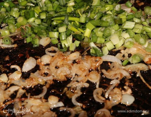 Отдельно обжариваем оставшуюся луковицу. Когда лук подрумянится, добавляем мелко нарезанный зеленый лук и припускаем его. 