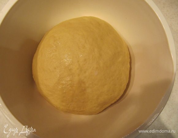 Добавить в опару слегка взбитые вилкой яйца и растопленное сливочное масло (масло должно быть теплым, не горячим!). Затем добавьте оставшуюся просеянную муку и щепотку соли. Вымесить тесто на слегка припыленной мукой поверхности около 7-10 минут.
Муки может понадобиться чуть больше или меньше. Ориентируйтесь на тесто. Оно должно получиться гладким и эластичным, не липнуть к рукам.
Положить тесто в глубокую чашу, смазанную тонким слоем растительного масла, накрыть пленкой и отправить в теплое место приблизительно на 1 час.