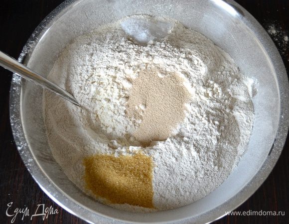 В миску просеять оба вида муки (пшеничную и ржаную), добавить дрожжи, сахар и соль. Перемешать.