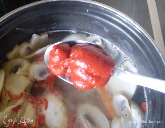 Добавить в суп морковь, чили и грибы, положить ложку томатной пасты.