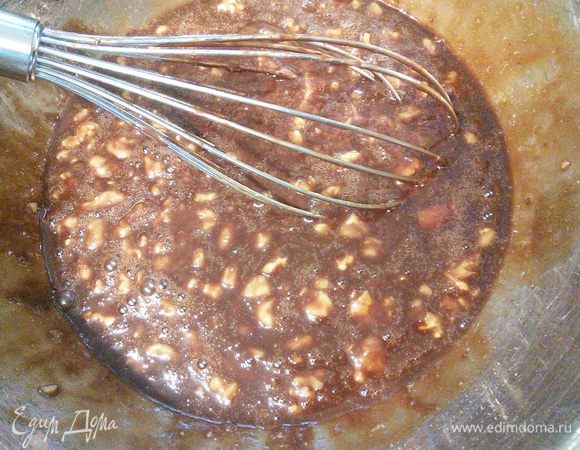 Влить тонкой струйкой шоколад, постоянно помешивая, чтобы яйца не заварились и добавить 3/2 от общего количества орехов, крупно поломанные руками. 