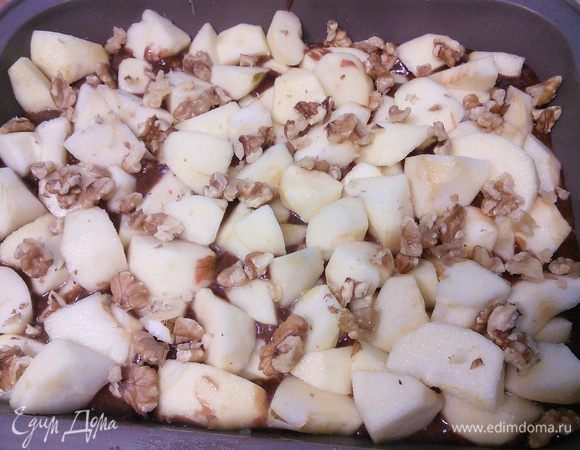 Форму (я делала половину порции - моя форма 20х20 см, силиконовая) смазать маслом и присыпать мукой. Выложить тесто, разровнять. Сверху разложить яблоки и оставшиеся орехи. 