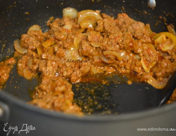 Добавить оливковое масло, раздавленный чеснок, карри, красный перец хлопьями. Перемешать, затем влить вино или мясной бульон, томатную пасту, тмин. Убавить огонь и тушить, помешивая, 20 мин.