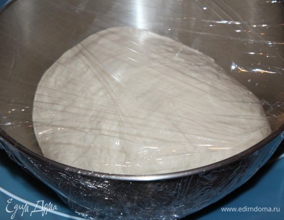 Теперь помещаем тесто в емкость, затягиваем пленкой и оставляем на ферментацию на 1 час. В процессе ферментации трижды, с интервалом в 20 минут, сложите тесто: раскатайте его в небольшой валик, расплюсните, сложите пополам по большей стороне, затем поднимаем меньшие края - один до середины, вторым накрываем, переворачиваем тесто швом вниз, чуть прокатываем руками и снова в емкость под пленку. И так - три раза. Помним, что формовка - это очень важно. Через 1 час тесто станет гладким. После последнего складывания, затягиваем пленкой и отправляем в холодильник на ферментацию на 21 час