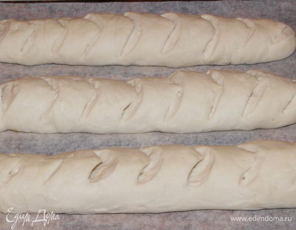 Накрываем вторым полотенцем и оставляем на расстойку на 45 минут. После расстойки перекладываем на противень с пергаментом, делаем надрезы. У меня не было острого лезвия. поэтому я работала ножницами.