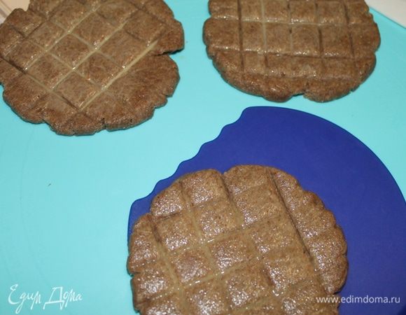 Раскатайте лепешки диаметром 10 см. Тупой стороной ножа сделайте насечки в виде квадратов и смажьте яйцом (добавьте в яйцо немного молока).