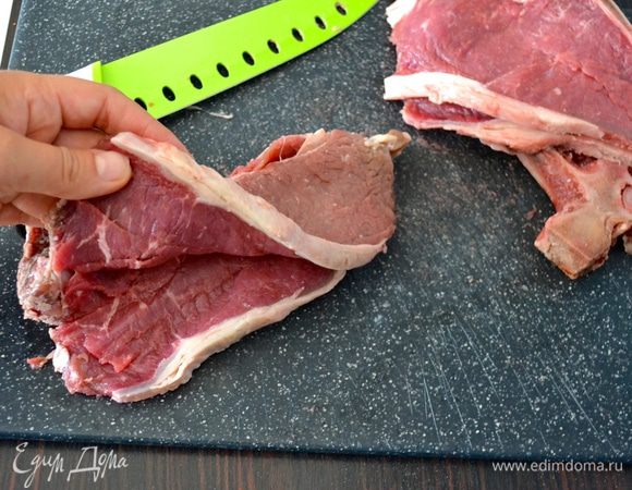 Отбивную вымойте и обсушите бумажным полотенцем. Используя острый нож с широким лезвием, разрежьте телячью отбивную, как книжку, доходя до косточки, но не разрезая до конца.