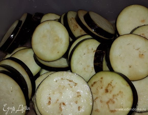 Баклажаны моем и режем кружочками толщиной примерно 0,5 см. Выкладываем в глубокую емкость, солим, перемешиваем и отставляем в сторону на 30 минут.