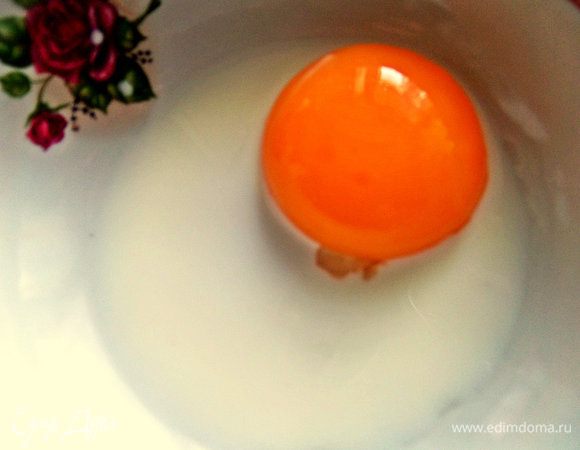 Отделить желток от белка и взбить с молоком.