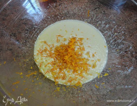 Яйцо взбить венчиком или миксером в 2 ст. л. сахара. Добавить цедру половины апельсина.