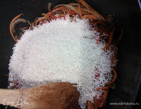Всыпать рис, ещё раз тщательно перемешать, чтобы рис обволокся в соках и специях. 