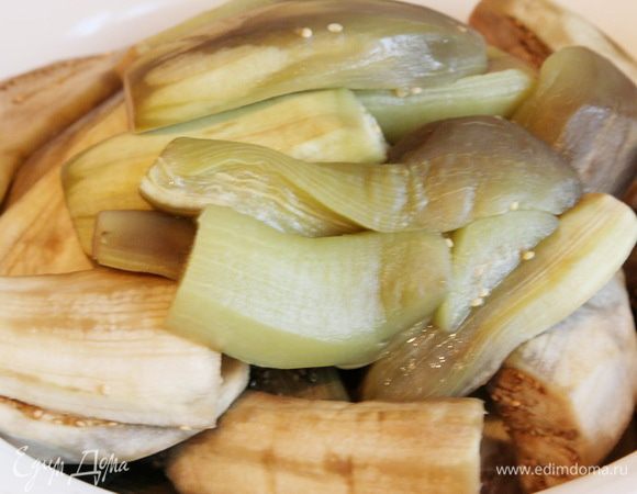 Баклажаны очищаем от кожуры (по рецепту - не чистим), режем пополам и отвариваем от 5 до 10 минут в рассоле из воды и 4 столовых ложек соли. Если у вас баклажаны небольшие, варите 5 минут, если побольше, то и готовите дольше. Главное, чтобы они не переварились, а то будет каша. Так, чтобы чуток прихватились. Вот у меня уже приваренные.