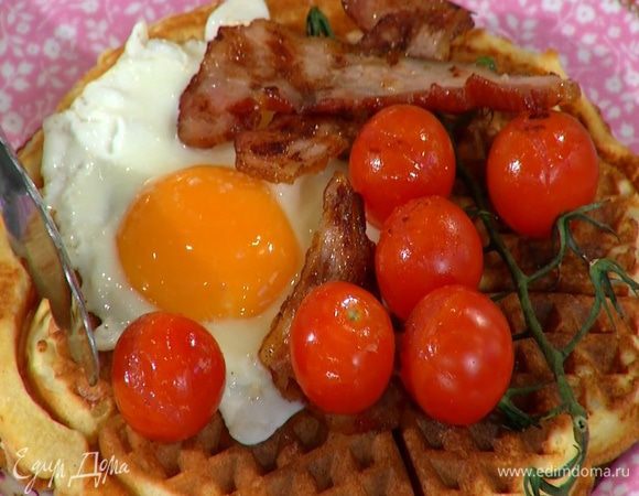 На готовые вафли выложить поджаренное яйцо, помидоры и грудинку.