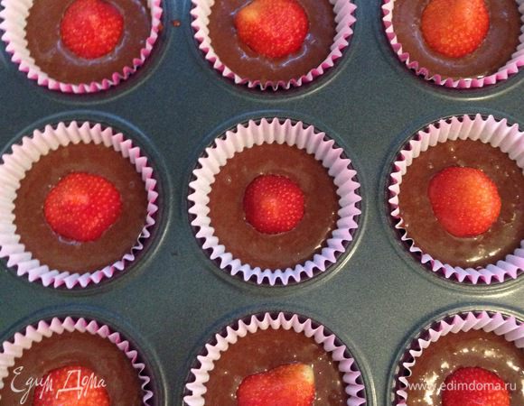 В формочки заливаем тесто по 2 столовые ложки в каждую лунку и ставим по 2-3 маленькие клубники или 1 большую.